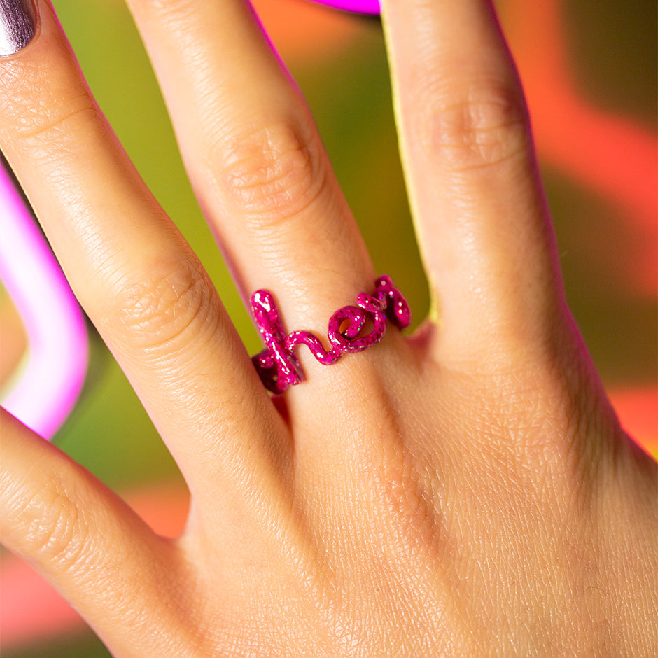 Cherie Hotscripts word ring in glitter pink enamel on hand