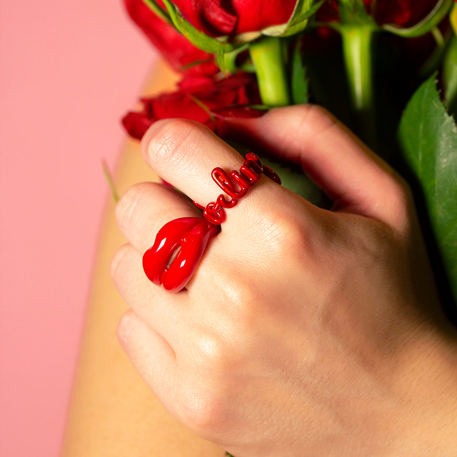 Darling red word ring and Hotlips classic red ring on hand roses
