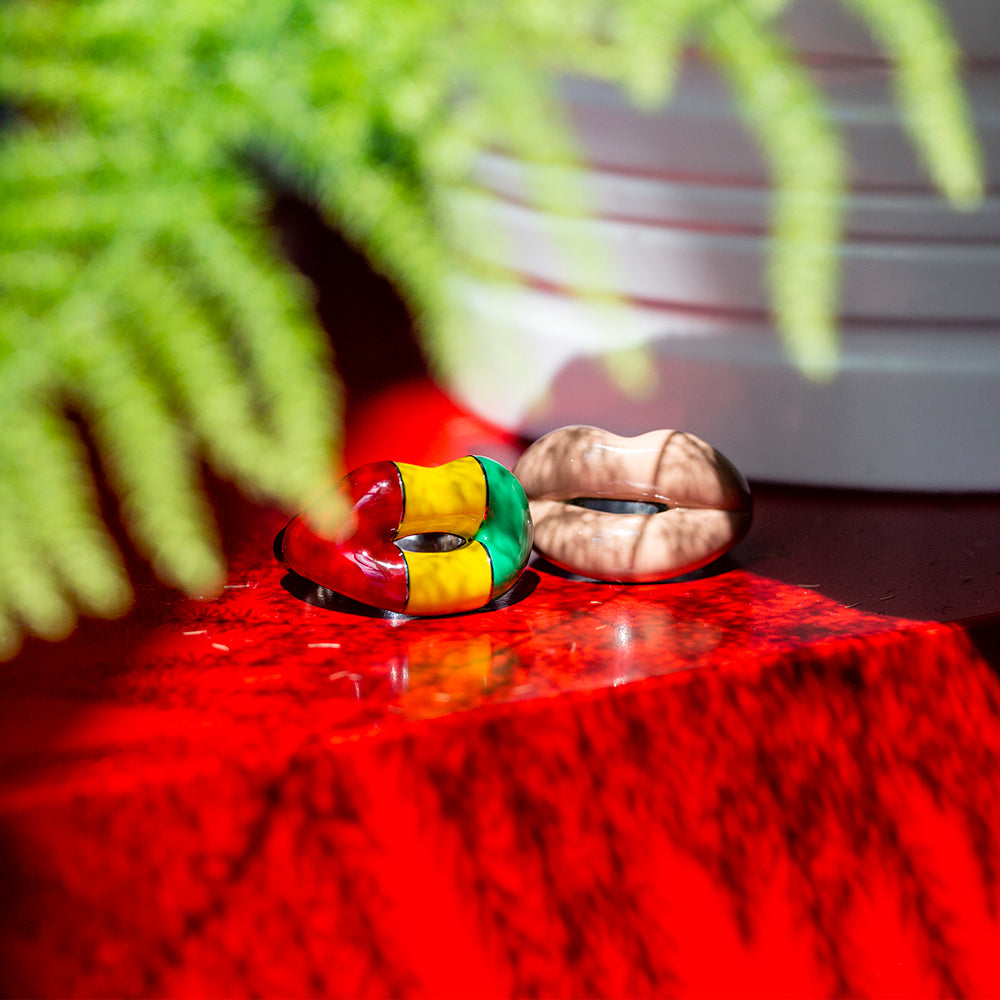 Rasta and Nude Hotlips ring on red table