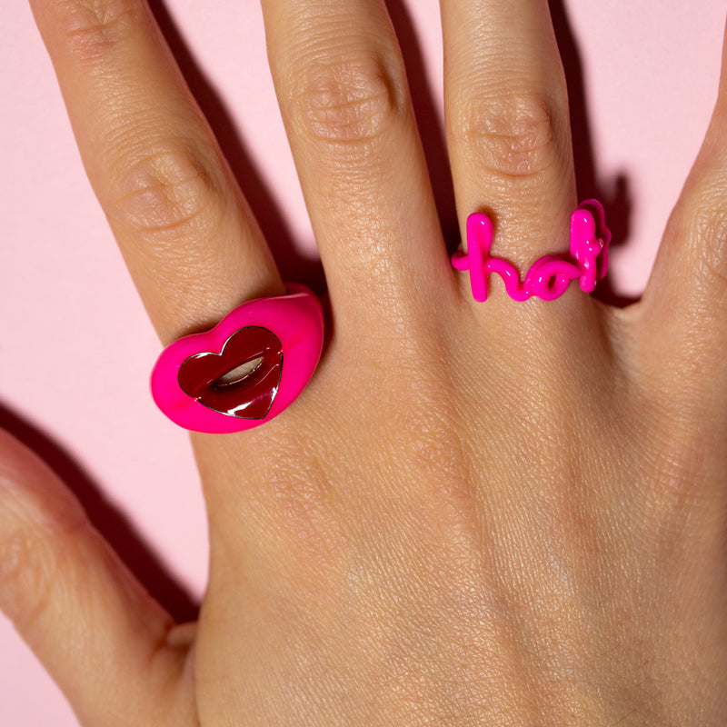 Loveheart Hotlips ring in neon pink and Hottie Hotscripts word ring on hand