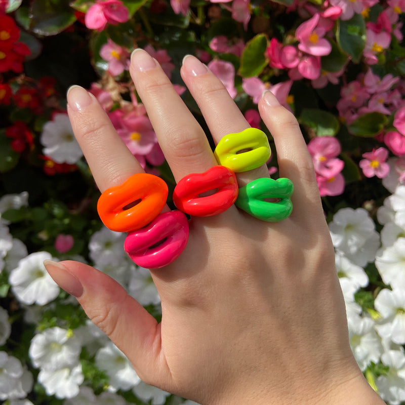 Neon Hotlips rings on hand with flowers